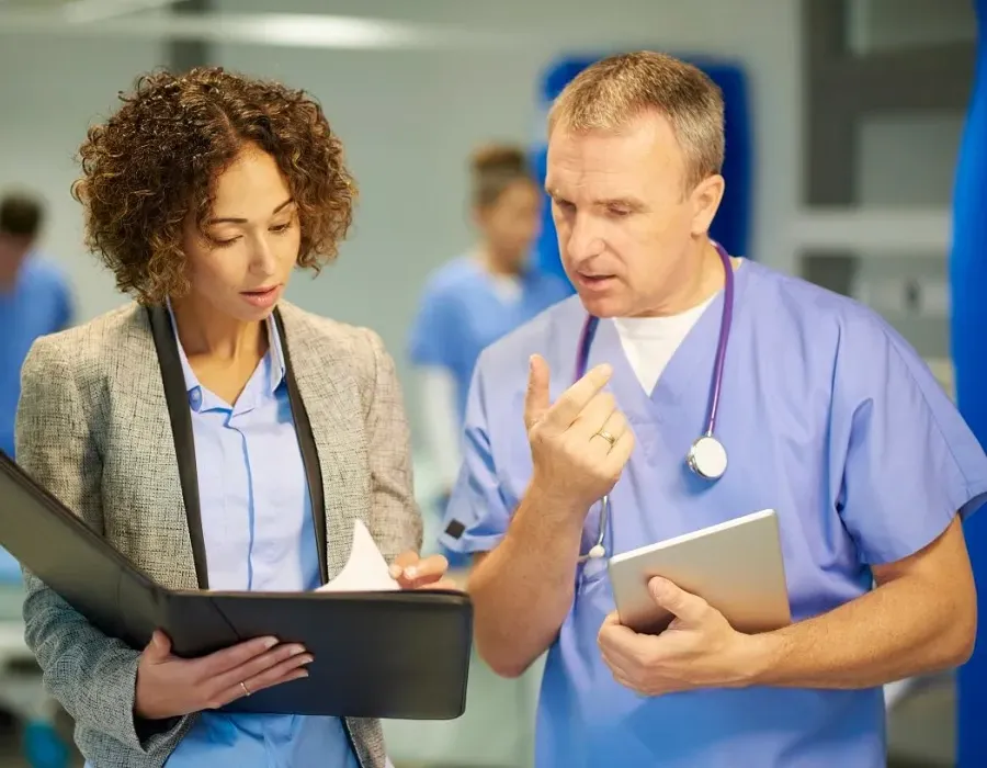 Nursing administrator reviewing patient diagnosis and treatment with registered nurse